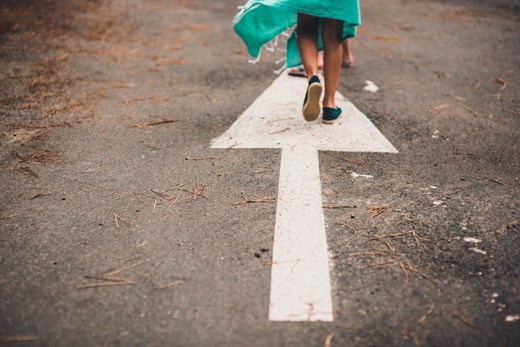 Arrow on road pointing to a young person